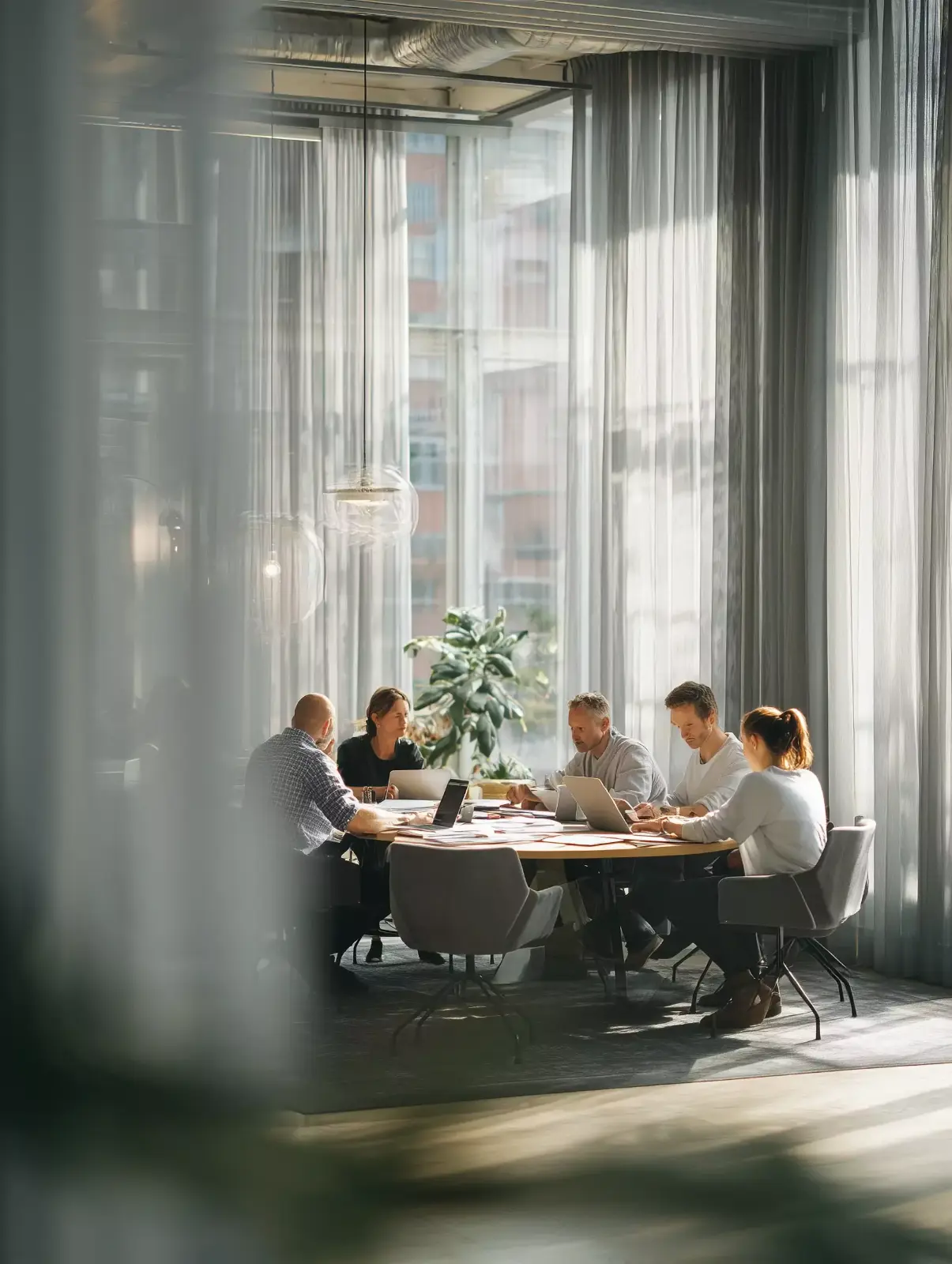 A team working together at a table by a tall window