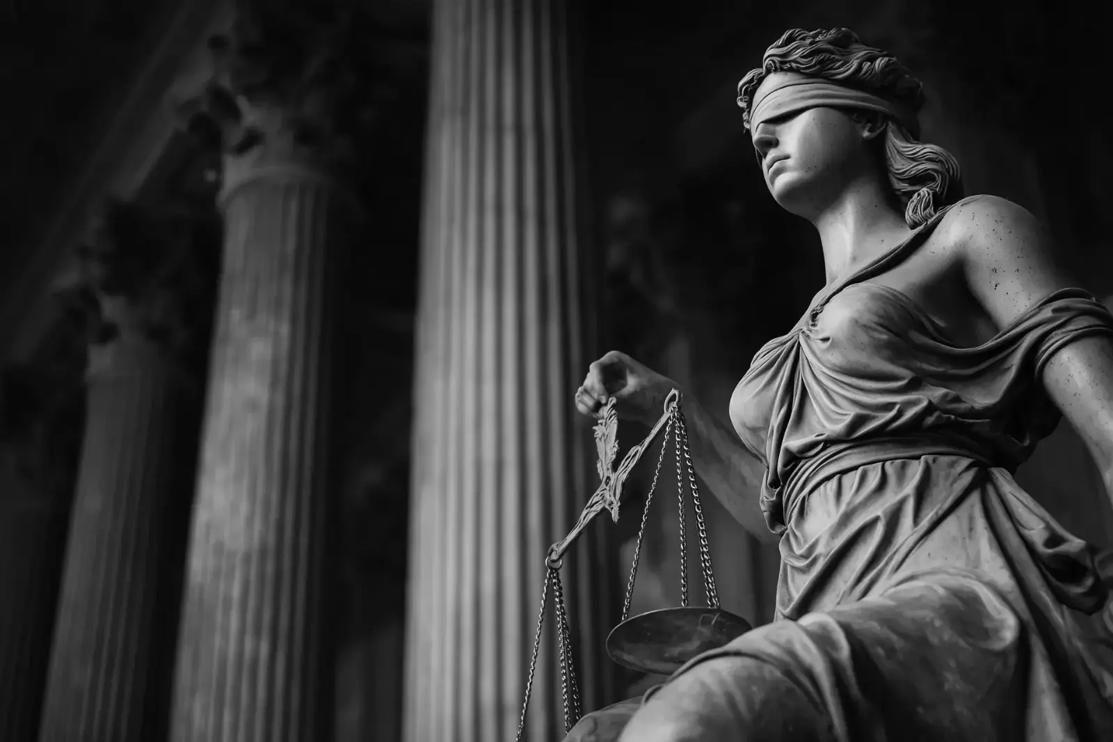 A statue of justice in front of tall columns