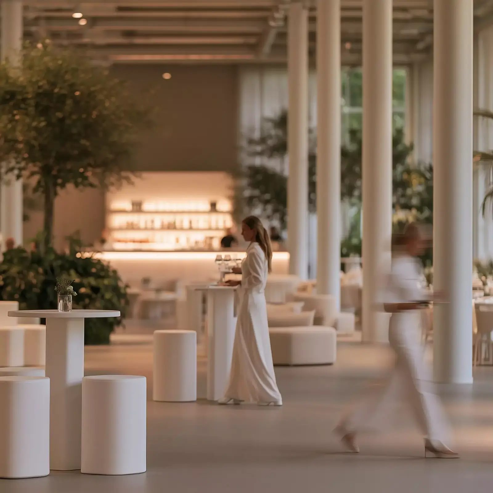 Bright event space with pendant lighting above long tables