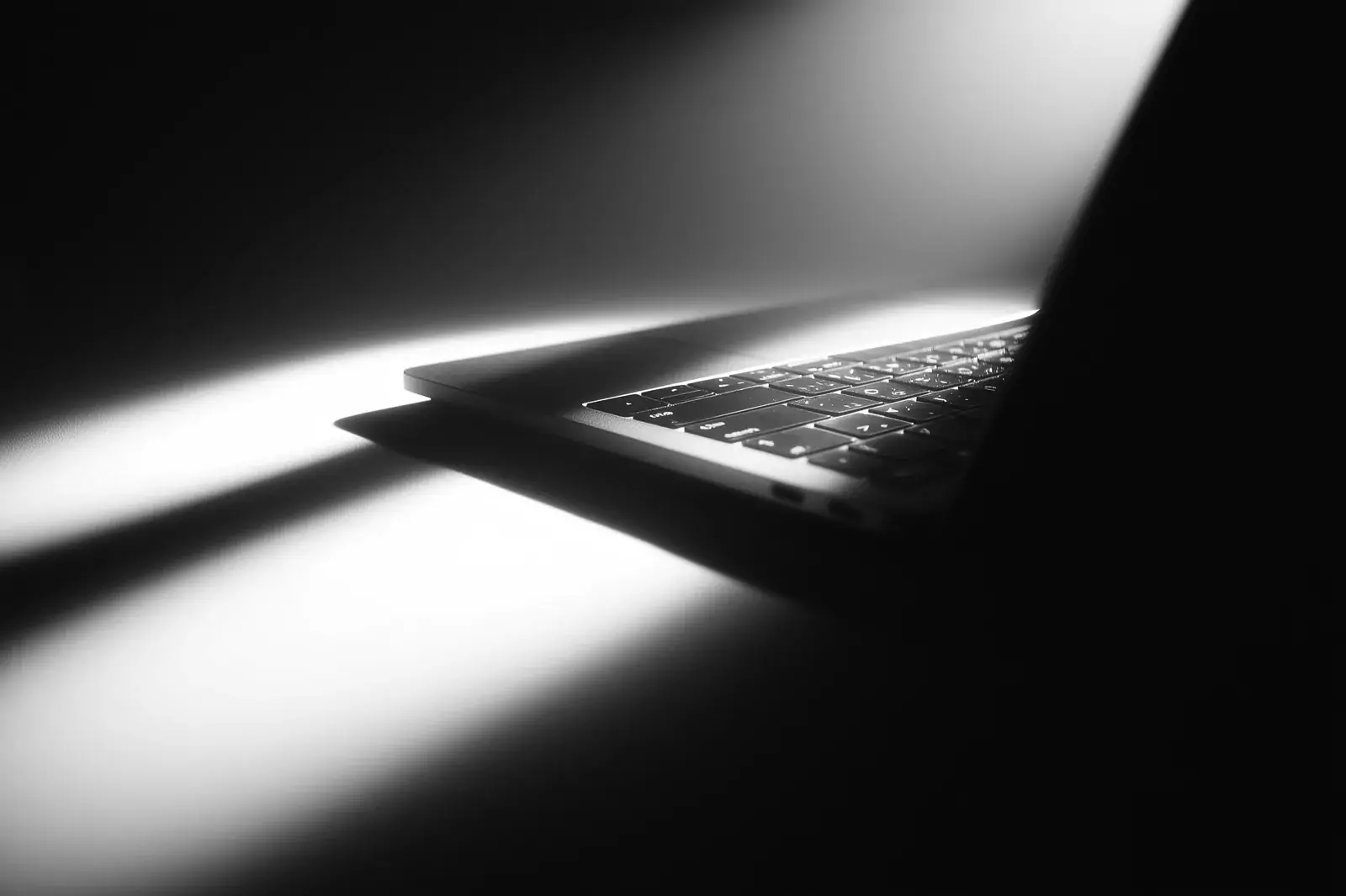 A laptop in a narrow shaft of light