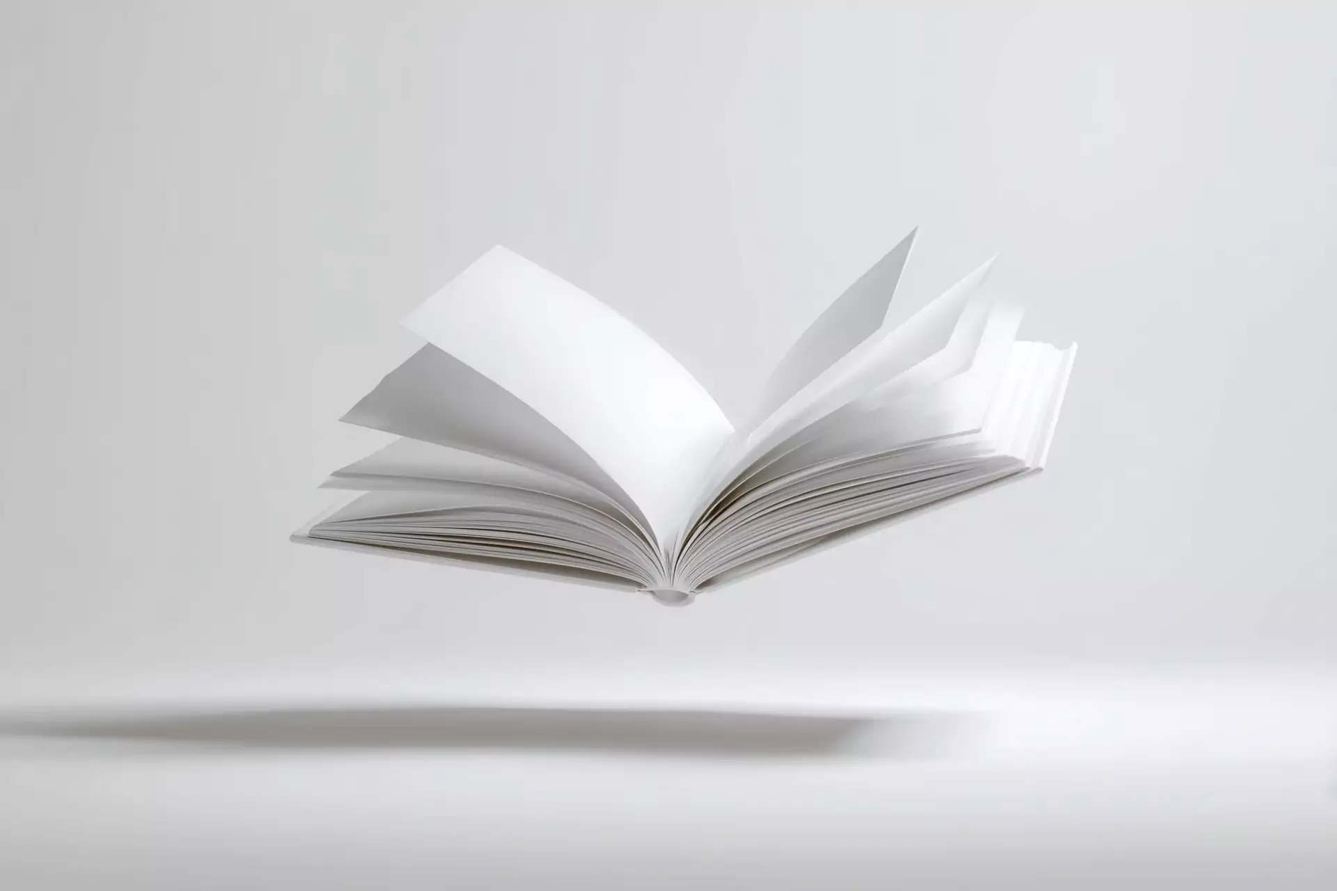 An open book floating against a pale wall