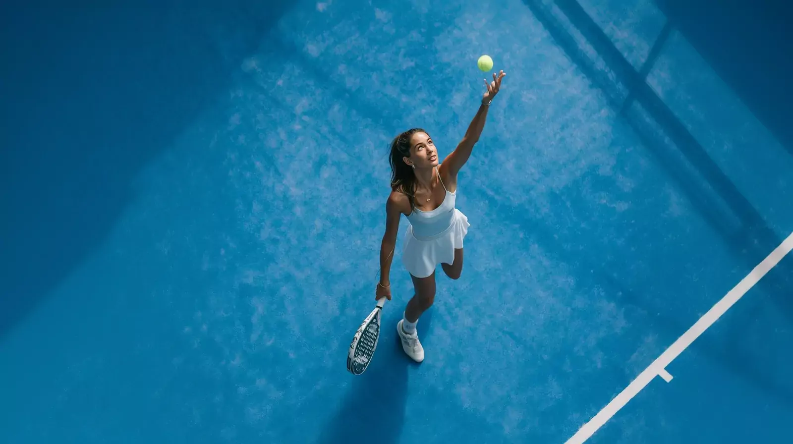 Serve seen from above on a blue court