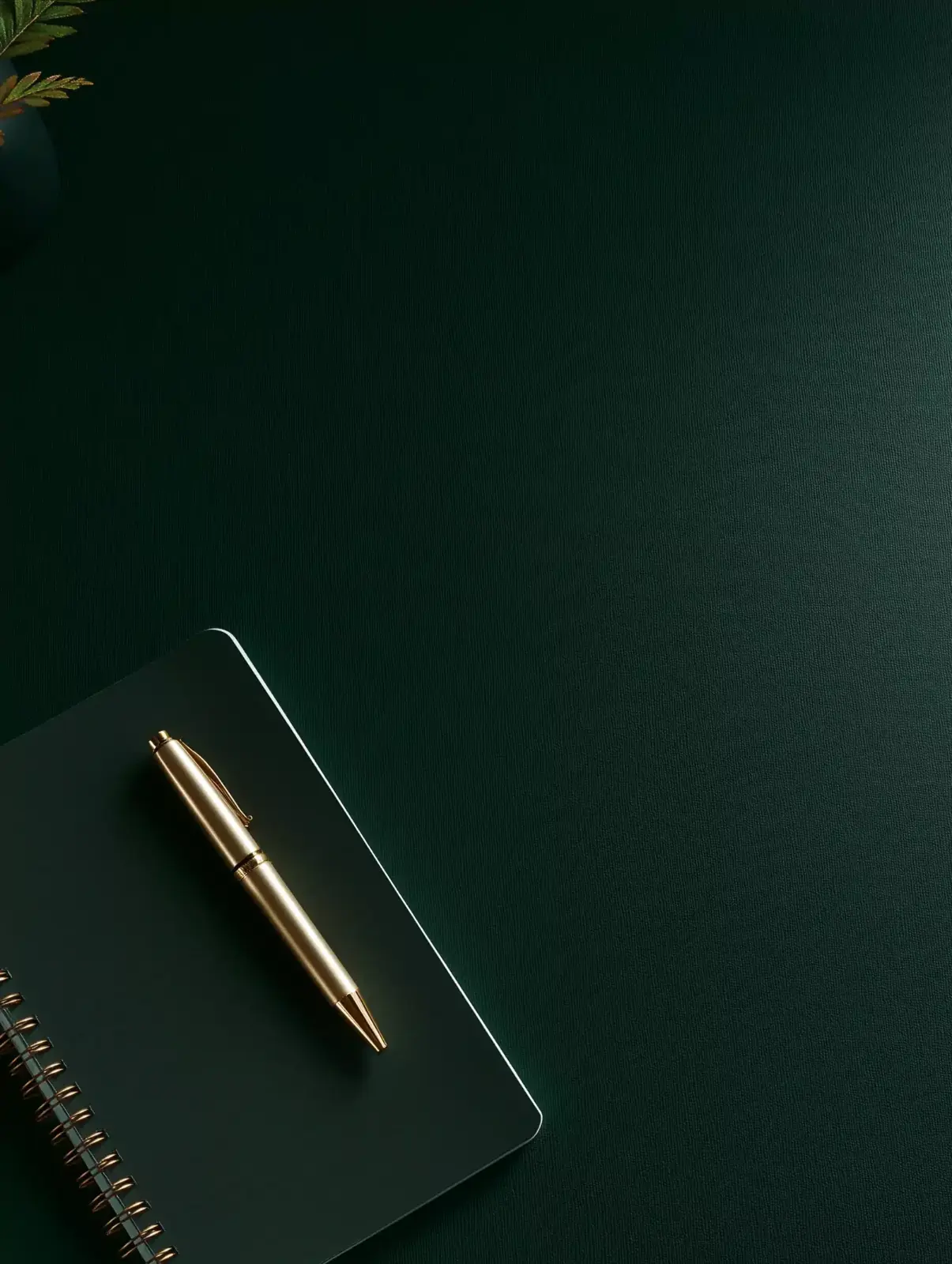 Still life with notebook and pen on a deep green desk