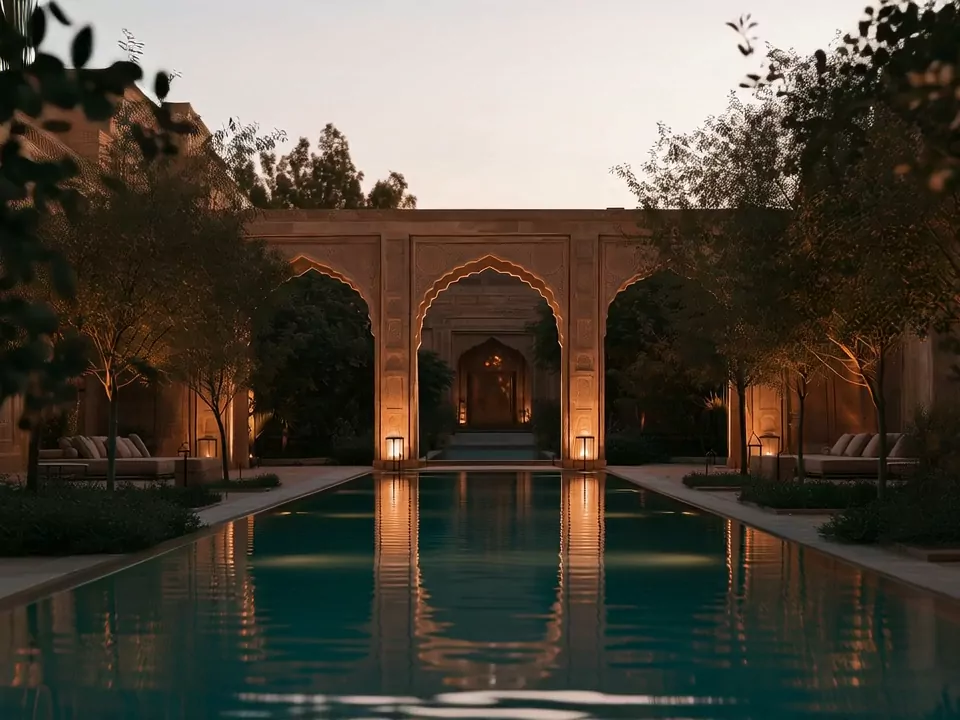 The long pool between trees, with lit arches at its far end