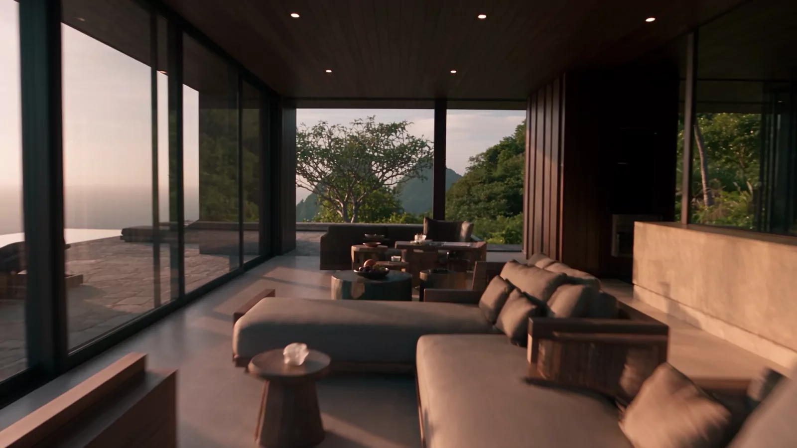 A low living room with a long sofa, a timber ceiling and glass walls onto the forest